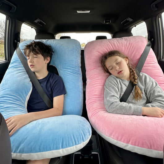 Two siblings in captain's chairs, each with their own Sleepy Miles pillow